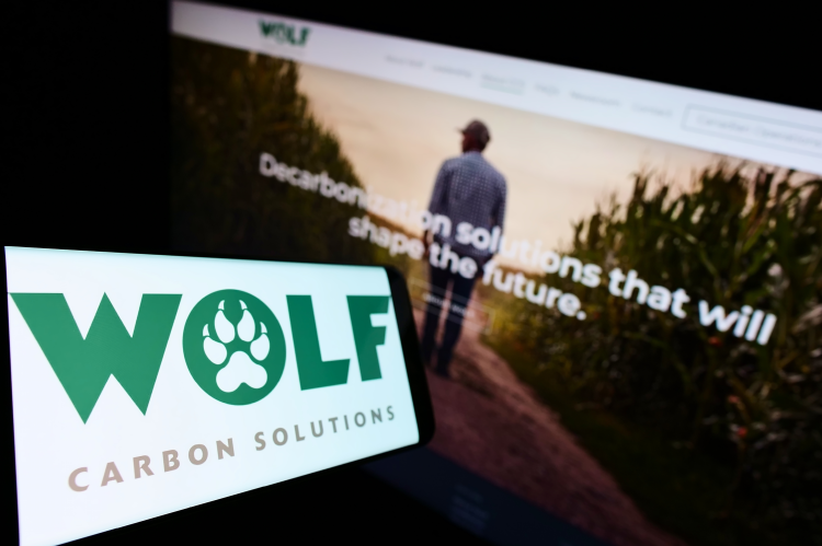Logo of Wolf Carbon Solutions on a screen infront of the website (© Shutterstock/T. Schneider)