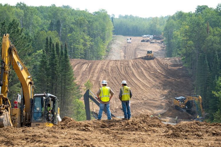 Workers overlook the Enbridge Line 3 Oil Pipeline in Minnesota (copyright by Shutterstock/Edgar Lee Espe)