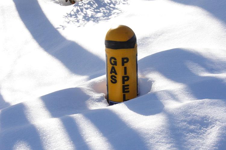 Marker for natural gas pipeline partly buried in snow after winter storm (copyright by Shutterstock/Imageforge)