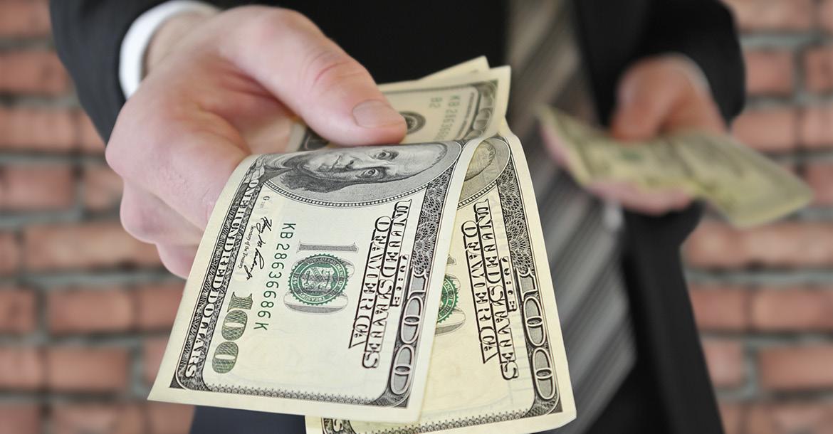 A man in a business suit offers money (© Shutterstock/Oleksandrum) 